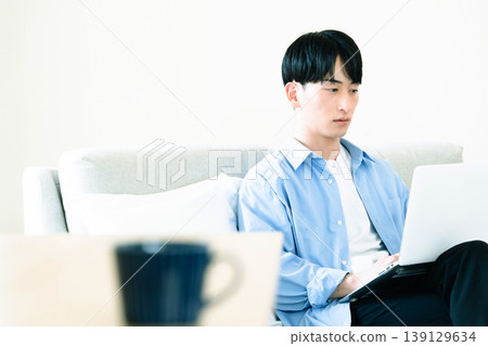 A man who uses a personal computer in the living room A man who uses a personal computer in the living room 139129634