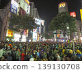 A nighttime event scene in Shibuya's bustling downtown area, with a large crowd gathered. Color halftone. 139130708