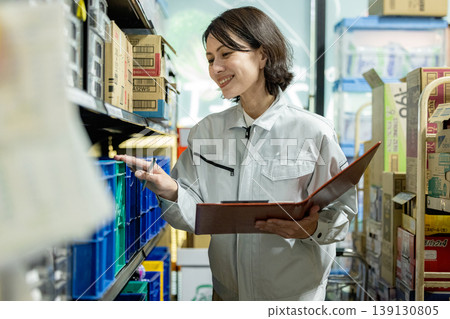 A part-time female employee checking inventory. A part-time female employee checking inventory. 139130805