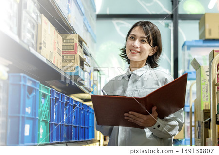A part-time female employee checking inventory. 139130807