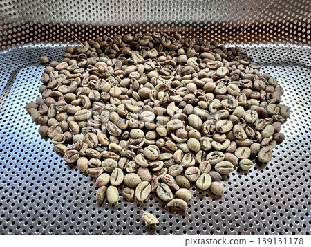 Defective coffee beans that have been rejected are placed in a stainless steel tray. Defective coffee beans that have been rejected are placed in a stainless steel tray. 139131178