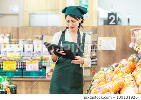 Female employee in charge of inventory management at a supermarket Female employee in charge of inventory management at a supermarket 139131920