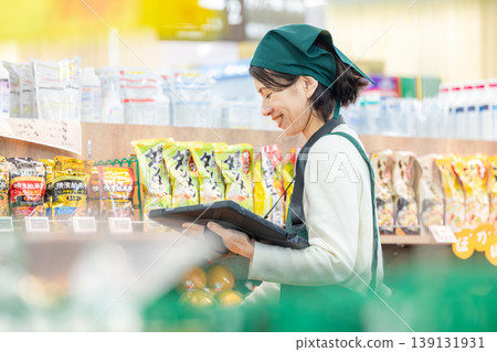 Female employee in charge of inventory management at a supermarket 139131931