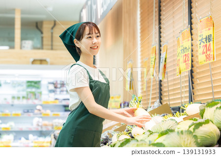 A woman working in the vegetable section of a supermarket A woman working in the vegetable section of a supermarket 139131933