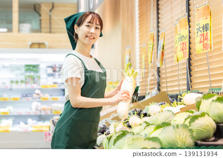 A woman working in the vegetable section of a supermarket A woman working in the vegetable section of a supermarket 139131934