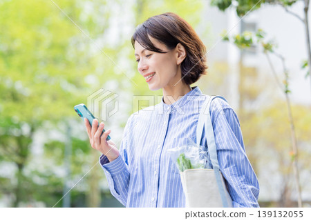 Middle woman looking at a smartphone Middle woman looking at a smartphone 139132055