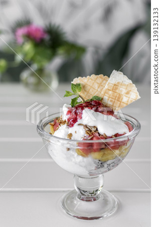 gelato ice cream and mixed fruit sundae dessert in glass cup on outdoor cafe white table gelato ice cream and mixed fruit sundae dessert in glass cup on outdoor cafe white table 139132133