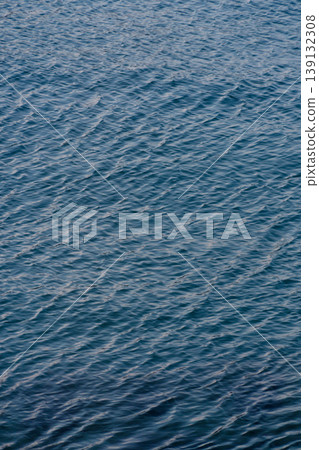 The texture of gentle ripples spreading across the deep blue surface of the sea. The texture of gentle ripples spreading across the deep blue surface of the sea. 139132308