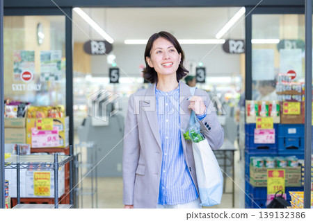 A woman who had finished shopping at a supermarket came out of the store. A woman who had finished shopping at a supermarket came out of the store. 139132386