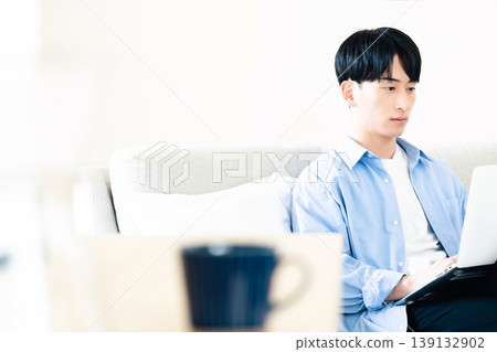 A man who uses a personal computer in the living room A man who uses a personal computer in the living room 139132902