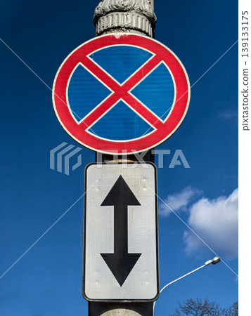 No Standing and No Parking Traffic Sign with Arrow Under Blue Sky No Standing and No Parking Traffic Sign with Arrow Under Blue Sky 139133175