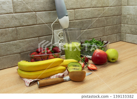 Preparing a healthy green smoothie with fresh fruits 139133382