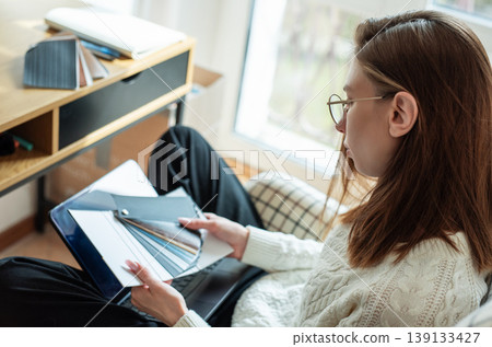 Woman choosing color swatches for home interior design Woman choosing color swatches for home interior design 139133427