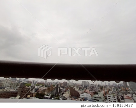 雨天的防火逃生梯和模糊的城市景觀;鐵欄桿的紋理。 雨天的防火逃生梯和模糊的城市景觀;鐵欄桿的紋理。 139133457