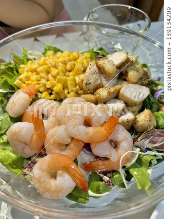 Fresh salad with a mix of crisp leafy greens, sliced vegetables, and colorful ingredients, tossed together to create a healthy, vibrant, and refreshing dish full of natural flavors 139134209