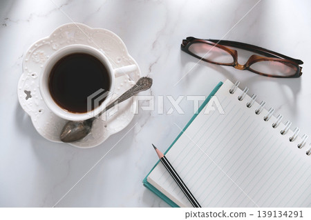 top table view of coffee, notebook, goggles and pencil, a creative breakfast journaling idea. top table view of coffee, notebook, goggles and pencil, a creative breakfast journaling idea. 139134291