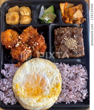 Bento or dosirak box filled with rice, assorted side dishes, vegetables, and protein like meat or fish, all neatly arranged to create a balanced, colorful, and visually appealing meal Bento or dosirak box filled with rice, assorted side dishes, vegetables, and protein like meat or fish, all neatly arranged to create a balanced, colorful, and visually appealing meal 139134300