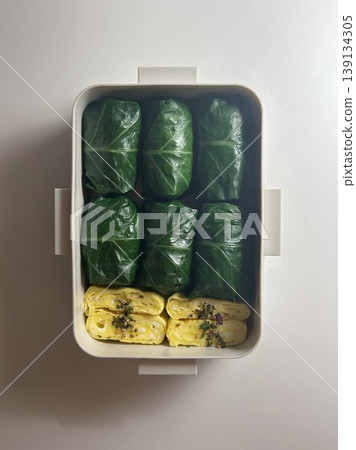 Bento or dosirak box filled with rice, assorted side dishes, vegetables, and protein like meat or fish, all neatly arranged to create a balanced, colorful, and visually appealing meal 139134305