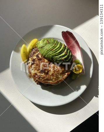 A delightful brunch spread featuring a mix of savory and sweet dishes, including fresh pastries, eggs, seasonal fruits, and a hot beverage. A perfect mid-morning indulgence. 139134311