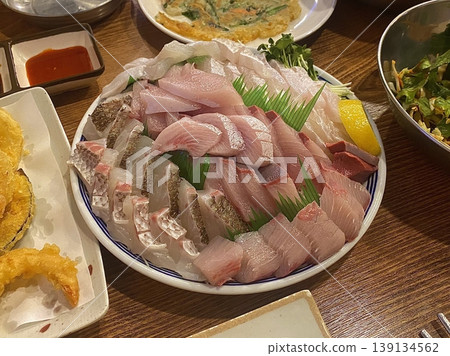 Fresh and delicate sashimi slices, beautifully presented with vibrant colors and perfect cuts. This traditional Japanese delicacy highlights the pure flavors of premium seafood. 139134562