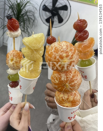 Tanghulu, a traditional Chinese snack made of skewered fruits, usually covered in a shiny sugar coating. Sweet and crunchy, this street food treat is a delightful combination of flavors and textures. 139134563