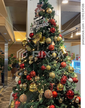 A beautifully decorated Christmas tree with twinkling lights, colorful ornaments, and a star on top. A symbol of warmth and joy, perfect for celebrating the holiday season. 139134586