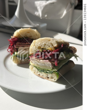 Delicious sandwich filled with fresh ingredients like crisp vegetables, tender meats, and savory spreads, all between two slices of soft bread. Perfect for a quick and satisfying meal. 139134601