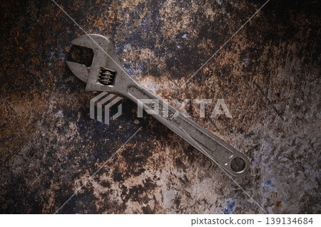 Adjustable wrench hand tools on a dark rusty metal background. Adjustable wrench hand tools on a dark rusty metal background. 139134684
