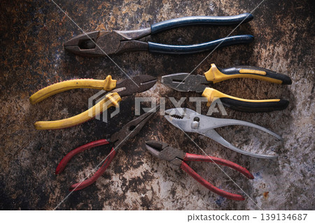 Various professional pliers and hand tools on rustic industrial background. 139134687