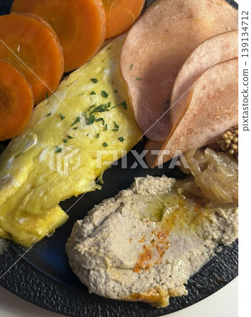 A delightful brunch spread featuring a mix of savory and sweet dishes, including fresh pastries, eggs, seasonal fruits, and a hot beverage. A perfect mid-morning indulgence. 139134712