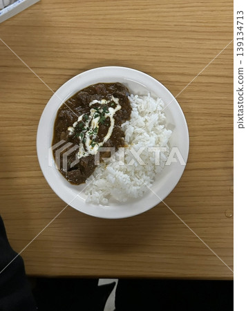 A comforting bowl of Japanese curry, featuring a rich, savory sauce with tender vegetables and chunks of meat, served over fluffy rice. A warm, flavorful dish perfect for any meal. 139134713
