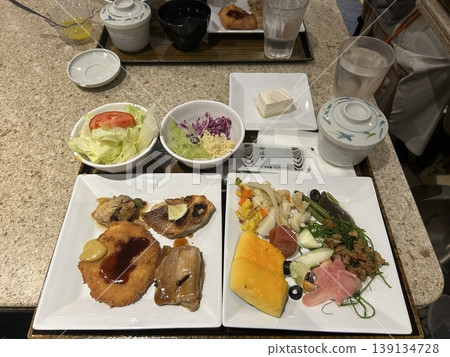 A delightful brunch spread featuring a mix of savory and sweet dishes, including fresh pastries, eggs, seasonal fruits, and a hot beverage. A perfect mid-morning indulgence. 139134728
