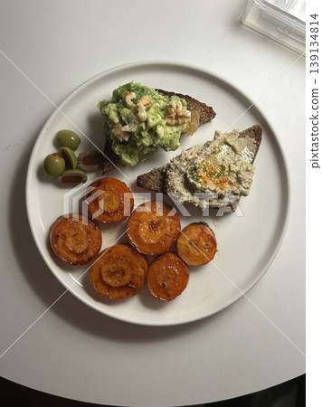 A delightful brunch spread featuring a mix of savory and sweet dishes, including fresh pastries, eggs, seasonal fruits, and a hot beverage. A perfect mid-morning indulgence. 139134814