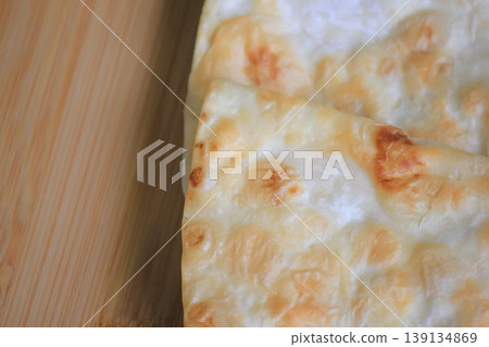 Top view close up of crispy layered flatbread on a wooden board with copy space for text Top view close up of crispy layered flatbread on a wooden board with copy space for text 139134869