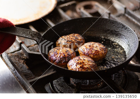 Grilling hamburgers in the kitchen Grilling hamburgers in the kitchen 139135650