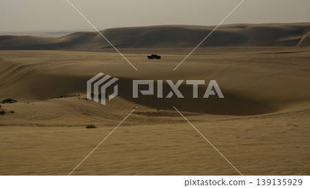 an off road vehicle driving in the desert an off road vehicle driving in the desert 139135929