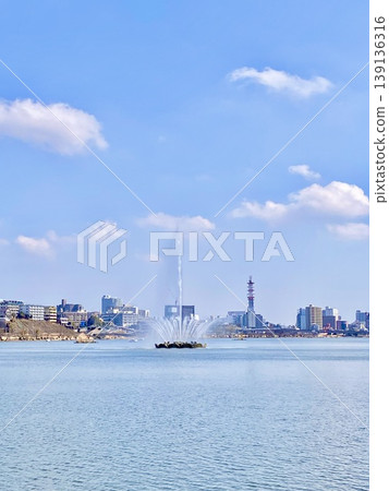 Blue sky, white clouds, and the fountains of Lake Senba rising into the air. Blue sky, white clouds, and the fountains of Lake Senba rising into the air. 139136316
