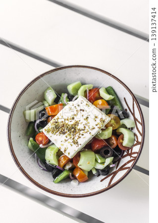 traditional greek feta cheese salad on white table at outdoor cafe in greece 139137414
