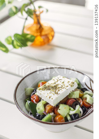 traditional greek feta cheese salad on white table at outdoor cafe in greece 139137416
