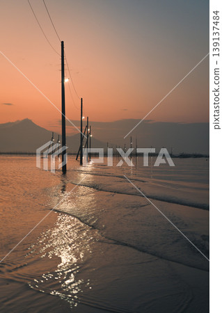 Utility pole sinking in the sea Utility pole sinking in the sea 139137484
