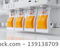 Industrial juice filling line automation sterile. Clear plastic bottles travel on conveyor under precision nozzles. Vibrant orange liquid flows into containers. Modern juice bottling sealing equipment 139138709