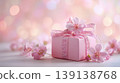 Beautiful pink flowers and wrapped gift box. Soft, celebratory atmosphere, bokeh lights in the background. Banner with space for text. Elegant giftbox. Spring holiday mood. Pastel colored dreamy glow. 139138768