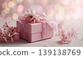 Beautiful pink flowers and wrapped gift box. Soft, celebratory atmosphere, bokeh lights in the background. Banner with space for text. Elegant giftbox. Spring holiday mood. Pastel colored dreamy glow. 139138769