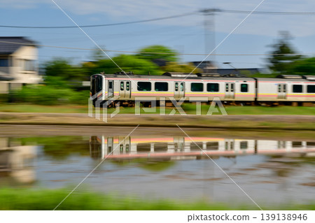 Reflection of a train running near rice paddies Reflection of a train running near rice paddies 139138946