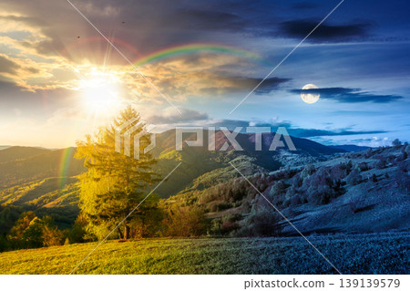 day meet night in mountainous rural landscape in spring. epic view of valley fields at twilight. sun and moon over alpine meadow. carpathian mountains countryside with forest near pasture. harmony 139139579