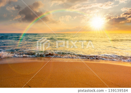 sunset over autumn vacation at the sea. beautiful seascape under rainbow. calm waves wash the sandy beach. image with cloudy sky above horizon. background for nostalgia or ads placement 139139584