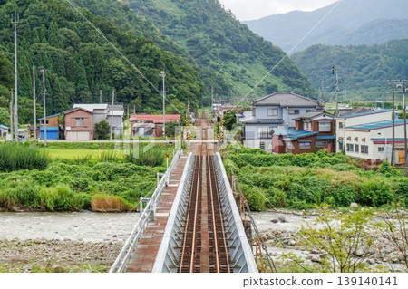 A railway line and bridge leading to a mountain village: A typical Japanese local railway scene. A railway line and bridge leading to a mountain village: A typical Japanese local railway scene. 139140141