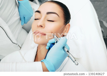 Jet peeling. Procedure renewing skin. Woman wants her skin to look young with with a cosmetic procedure Jet peeling. Procedure renewing skin. Woman wants her skin to look young with with a cosmetic procedure 139140627