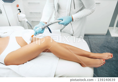 Laser hair removal on beautiful female legs. Laser cosmetologist doing legs smooth and hair free. Laser hair removal on beautiful female legs. Laser cosmetologist doing legs smooth and hair free. 139140639
