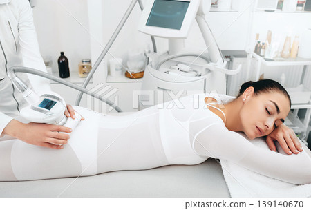 Beautician doing cellulite removal procedure on female buttocks at spa salon. Woman wants to have a very beautiful figure 139140670